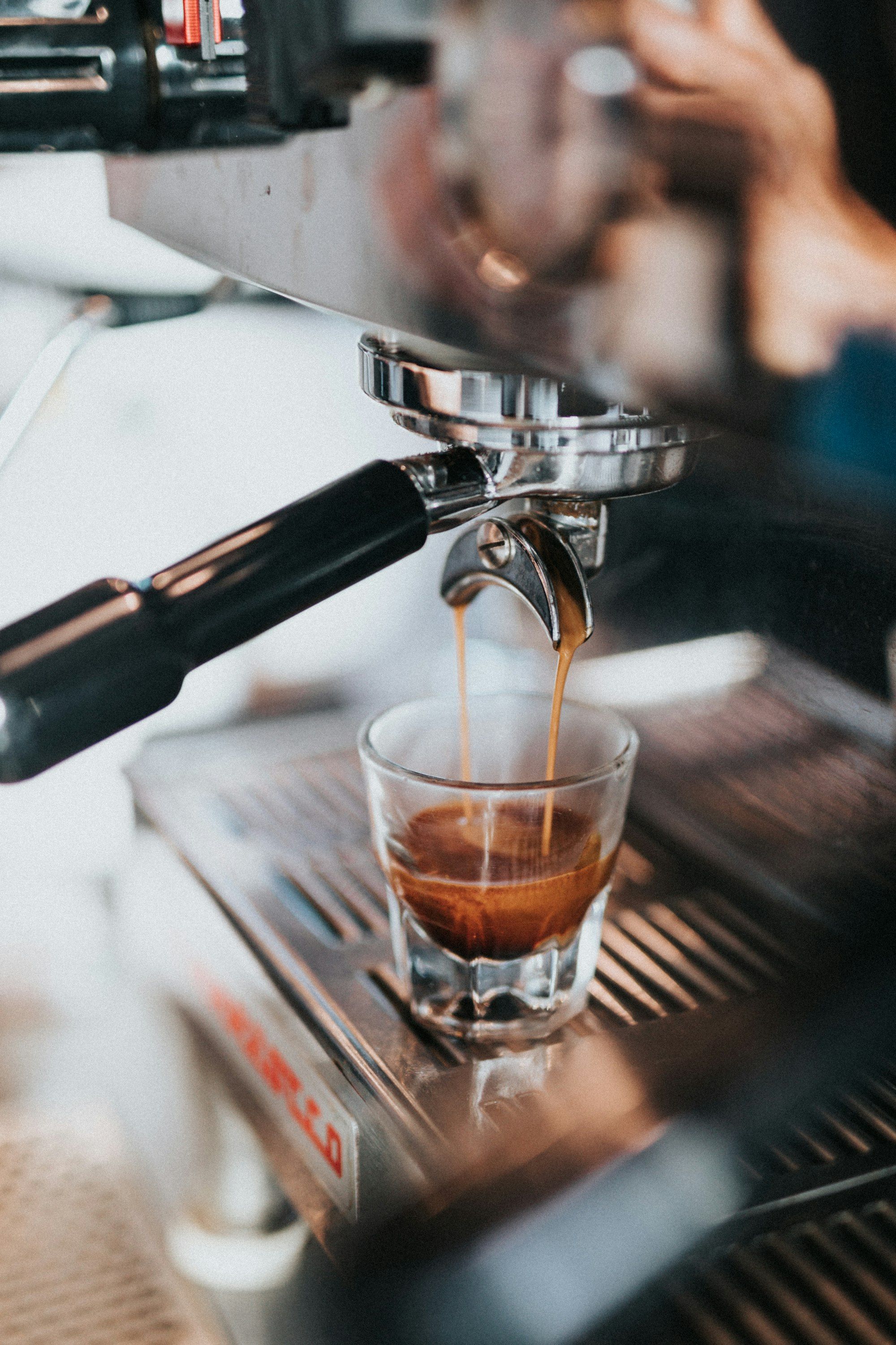 Gelas kaca menampung espresso yang mengalir dari mesin