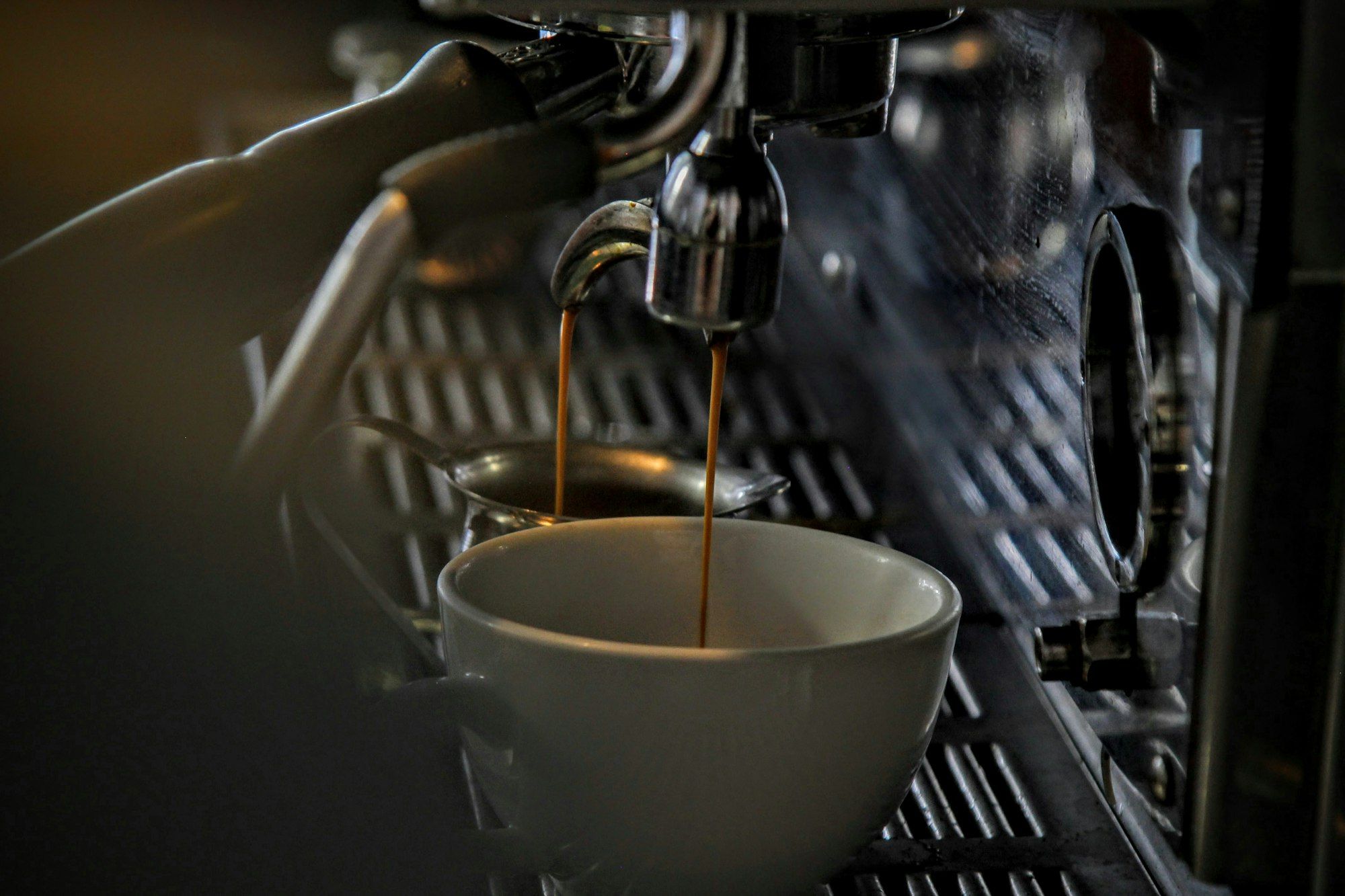 Espresso menetes ke cangkir porselen dari group head