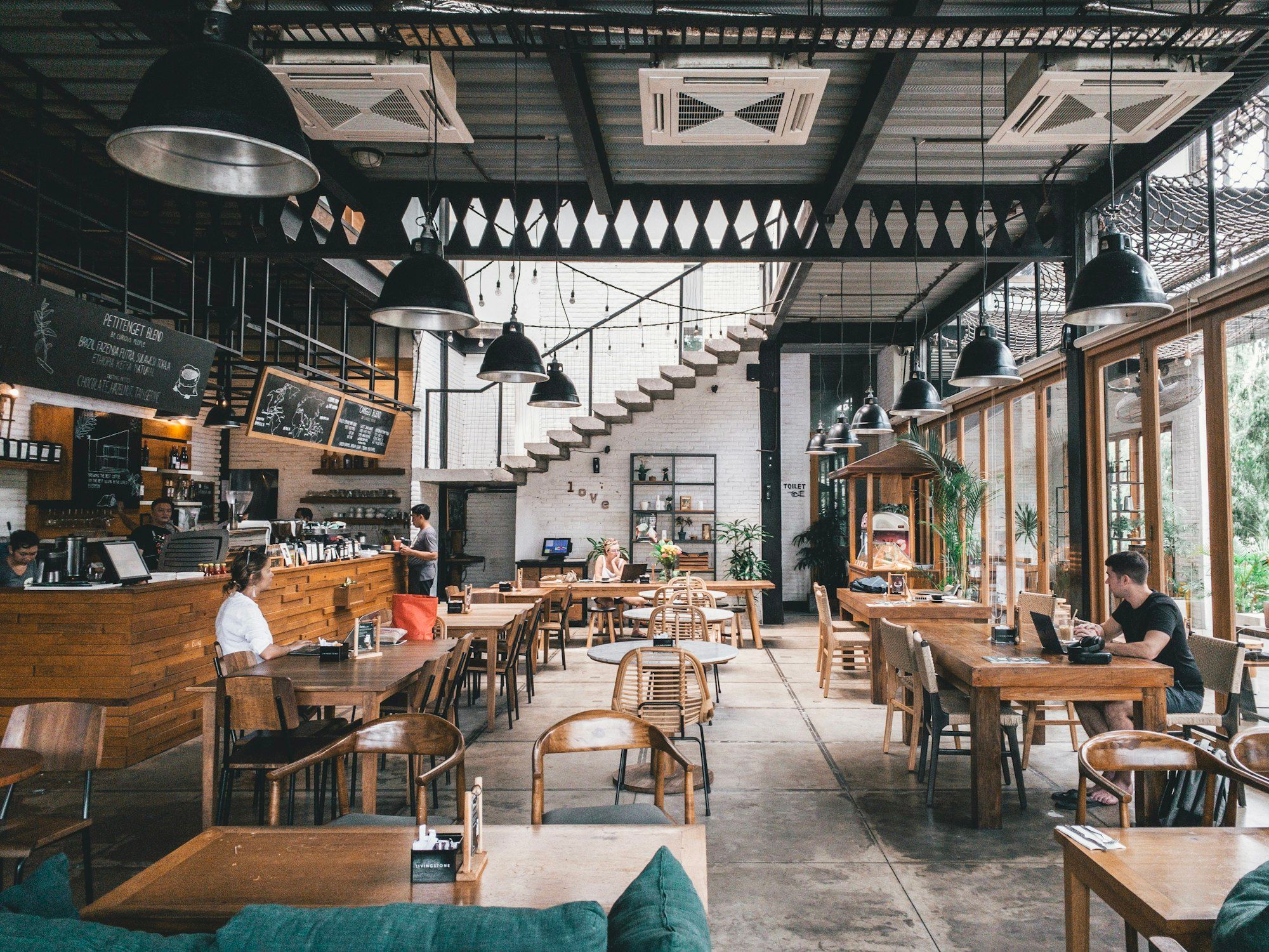 Bagian dalam kedai kopi kecil dengan meja kayu